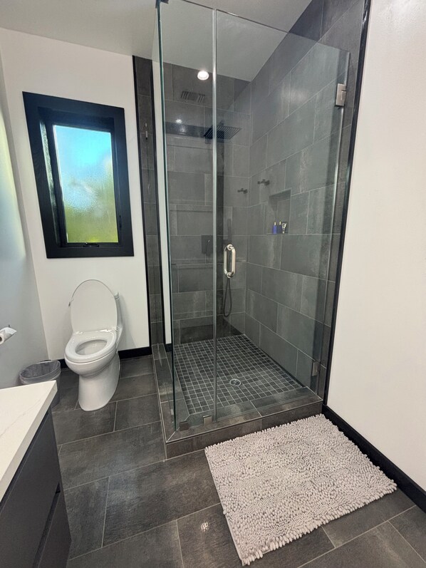 A modern bathroom with a glass-enclosed shower, a toilet, and a sink. - Burbank - Starlight Hills Luxury Guest House (Burbank)