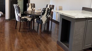A dining area with a wooden table and chairs, a ceiling fan, and artwork on the walls. - Charming 3-bedroom upstairs apartment in welcoming Fennimore. (Fennimore)