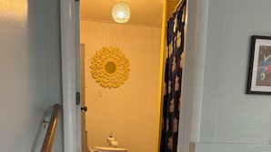 A staircase leading to a bathroom with a toilet, sink, and decorative mirror.