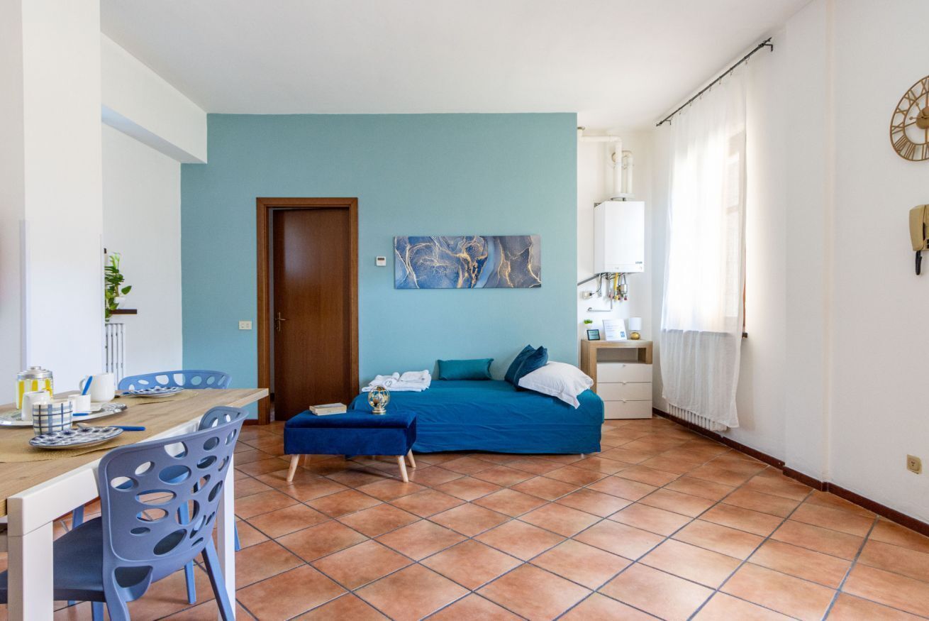 A bedroom with a bed, a desk, and a chair.