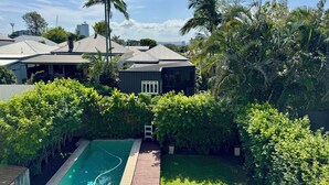 Un quartier résidentiel doté d’une piscine, d’une terrasse en bois et d’une végétation luxuriante.