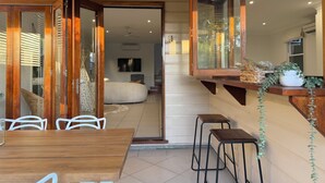 Un intérieur moderne avec une table à manger en bois, des chaises blanches et un grand miroir.