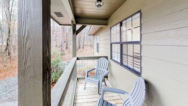 A wooden porch with two Adirondack chairs, a window with bars, and a view of a wooded area. - Dogs Welcome! 'Big Oak Hideaway' Near Lake Martin (Eclectic)