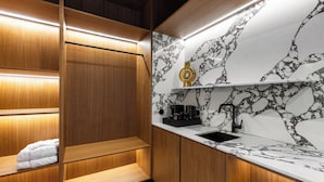 A modern kitchen with a marble backsplash, wooden cabinetry, and built-in shelves.