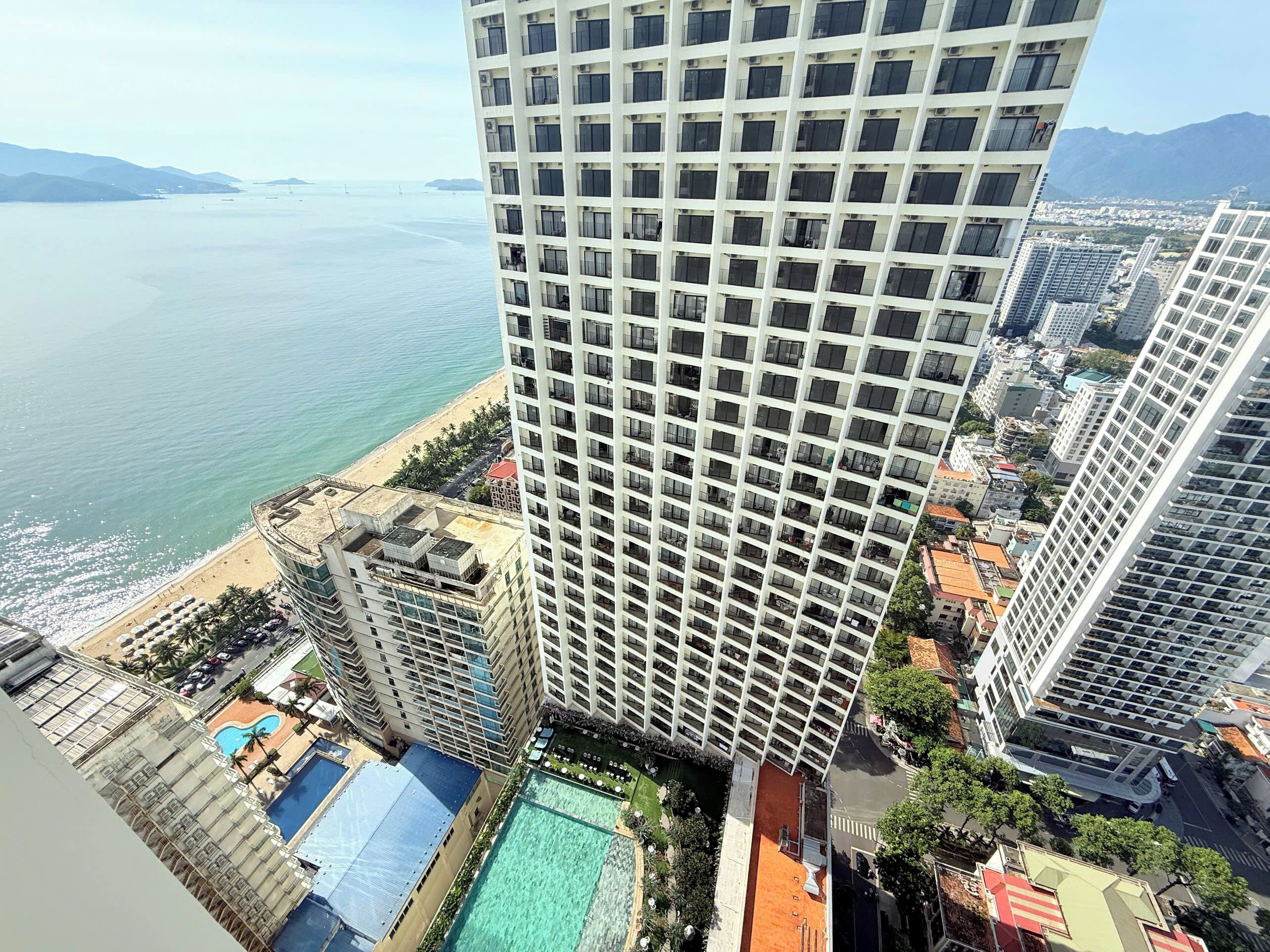 Pantai di sekitar, pasir putih, kursi berjemur, dan payung pantai
