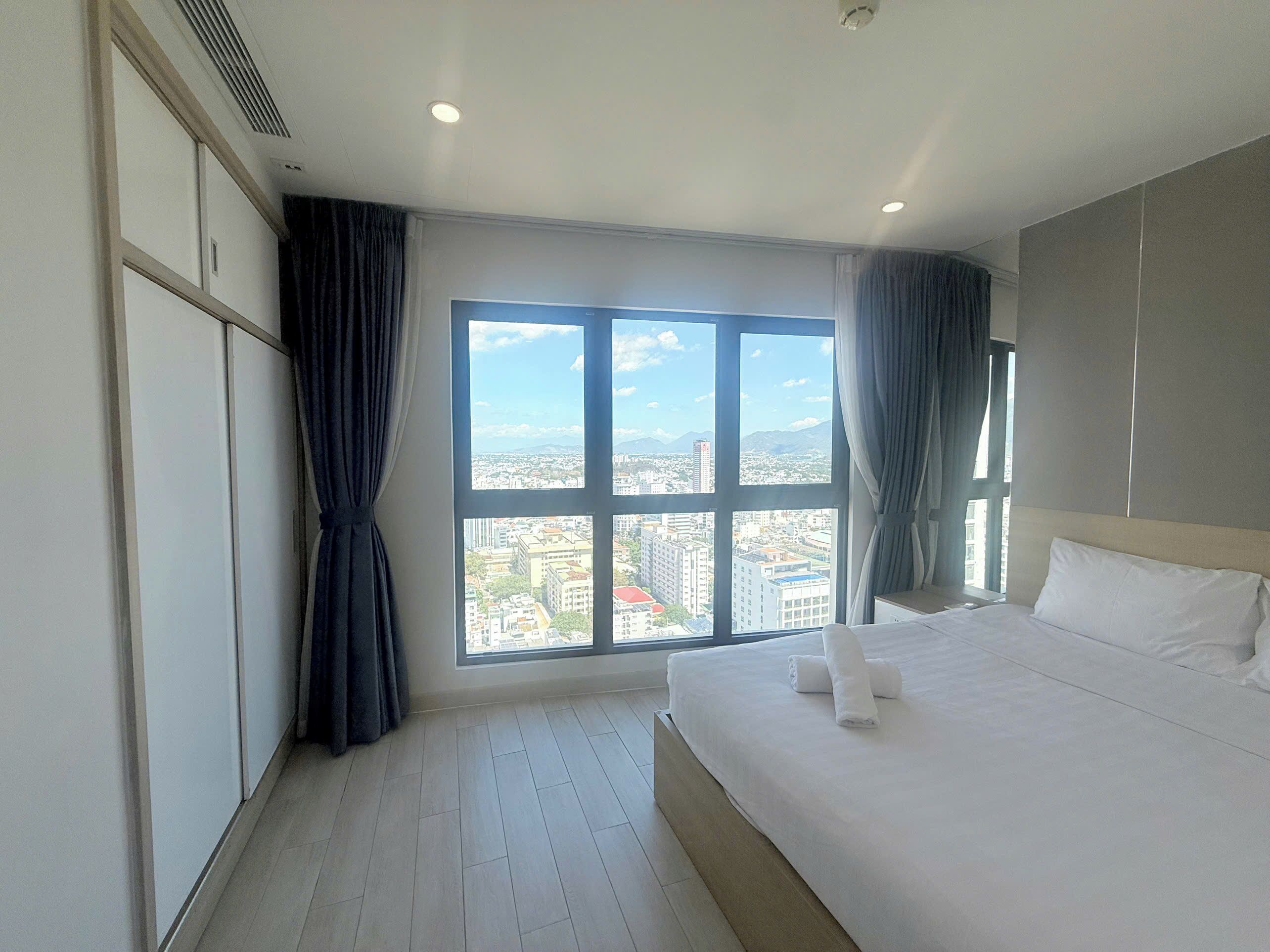Habitación de hotel con un ventanal grande, una cama y un armario.