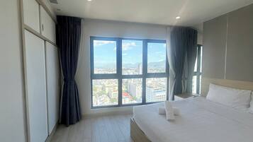 Habitación de hotel con un ventanal grande, una cama y un armario.