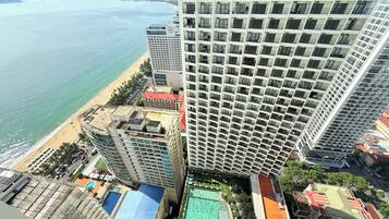 Pantai di sekitar, pasir putih, kursi berjemur, dan payung pantai