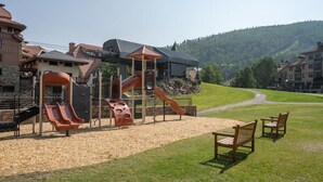 A playground with slides and a pavilion, surrounded by a grassy area and a mountain in the background. - VIEWS!!! Luxury Retreat • Panoramic Mountain Views • Steps to Gondola (Mountain Village)
