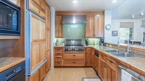 A kitchen with wooden cabinets, a stainless steel stove, and a dishwasher. - VIEWS!!! Luxury Retreat • Panoramic Mountain Views • Steps to Gondola (Mountain Village)