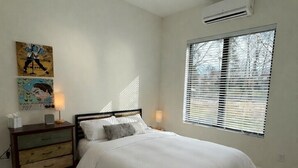 A bedroom with a bed, bedside tables, a ceiling fan, a window with blinds, and a floral rug. - Tranquil 1 bedroom in-law suite - walking distance to downtown Delafield (Delafield)
