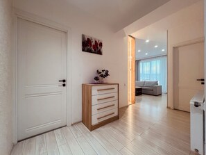 Un salon moderne avec un meuble en bois, un canapé et un tableau accroché au mur.