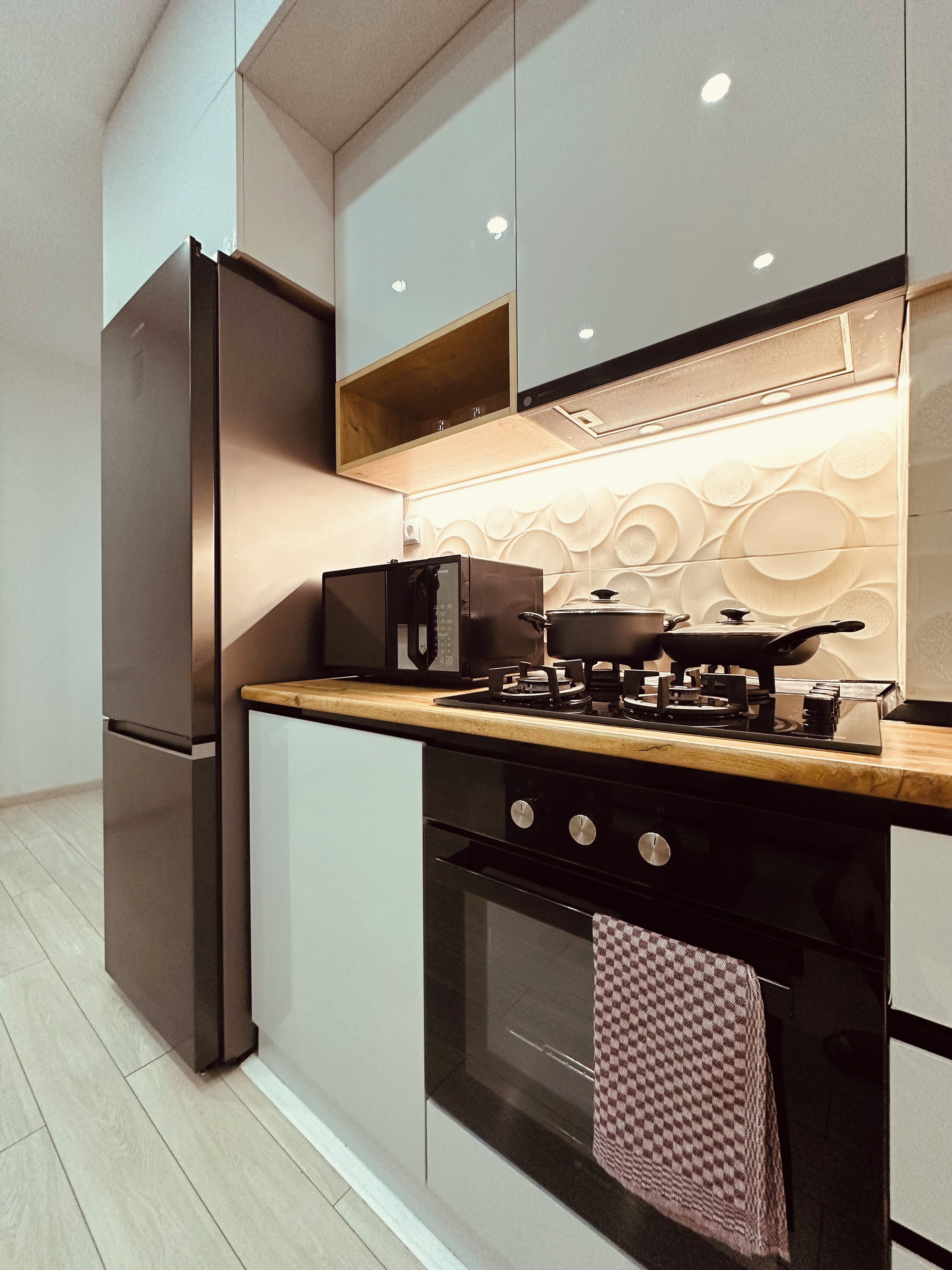 Una cocina moderna con horno empotrado, refrigerador y estufa.