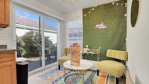 A modern living room with a green wall, a neon sign, and a brick tower centerpiece. - Modern Luxury Home near Denver (Westminster)