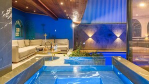 Uma sala de estar moderna com um sofá bege, uma mesa de centro e uma janela grande.