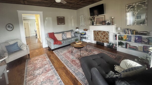 A living room with a fireplace, a sofa, a coffee table, and a bookshelf. - "5 Mins Driving Distance from The Ark Encounter & Creation Museum" (Williamstown)