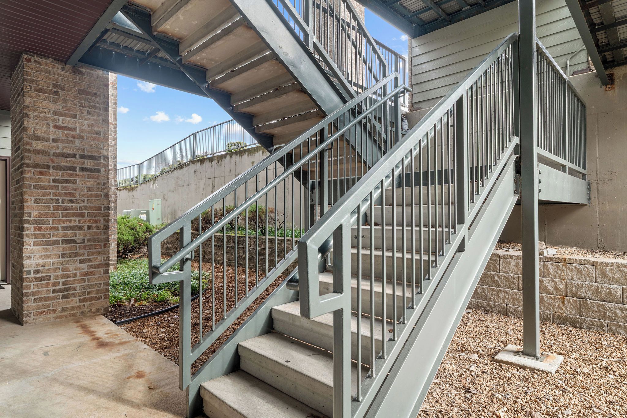 Un escalier en métal, doté d’une rampe, mène à un niveau supérieur.