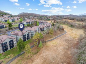 A residential area with multiple two-story houses, a winding road, and a large open field. - Golf Course View from Screened Porch, Near Silver Dollar City with Free Tickets, Gated Resort (Reeds Spring)