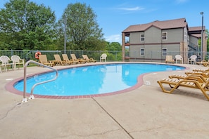 A swimming pool with lounge chairs and a lifeguard stand. - Golf Course View from Screened Porch, Near Silver Dollar City with Free Tickets, Gated Resort (Reeds Spring)