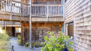 Een houten gebouw met balkon en een tuin.