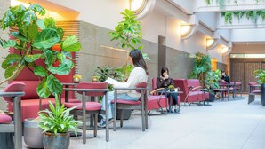 Un área de estar interior moderna con sillas rojas y plantas en macetas.