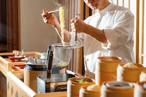 A chef preparing noodles with a strainer and cooking utensils. - Koraku Garden Hotel (Tokyo)