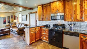 Una cocina con armarios de madera, estufa, horno y lavavajillas.