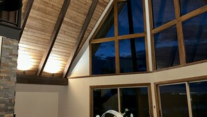 Un interior moderno con techo inclinado, ventanas grandes y piso de madera.
