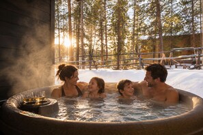A hot tub with four people in a snowy outdoor setting. - Luxe 3Br Townhome w/ Private Hot Tub, Sauna, Walk to Village and Gondola! (Dillon)