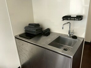 A modern kitchen with a stainless steel sink, a black towel holder, and a black towel stack. - 6 min to Roppongi St! Spacious 5BR apt, 12 beds,140㎡,sleeps up to 12 guests. (Roppongi, Minato)