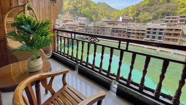 Un balcón de madera con vistas a edificios tradicionales y un río.