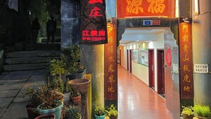 Entrada de hotel con un letrero que muestra el nombre y número de contacto.