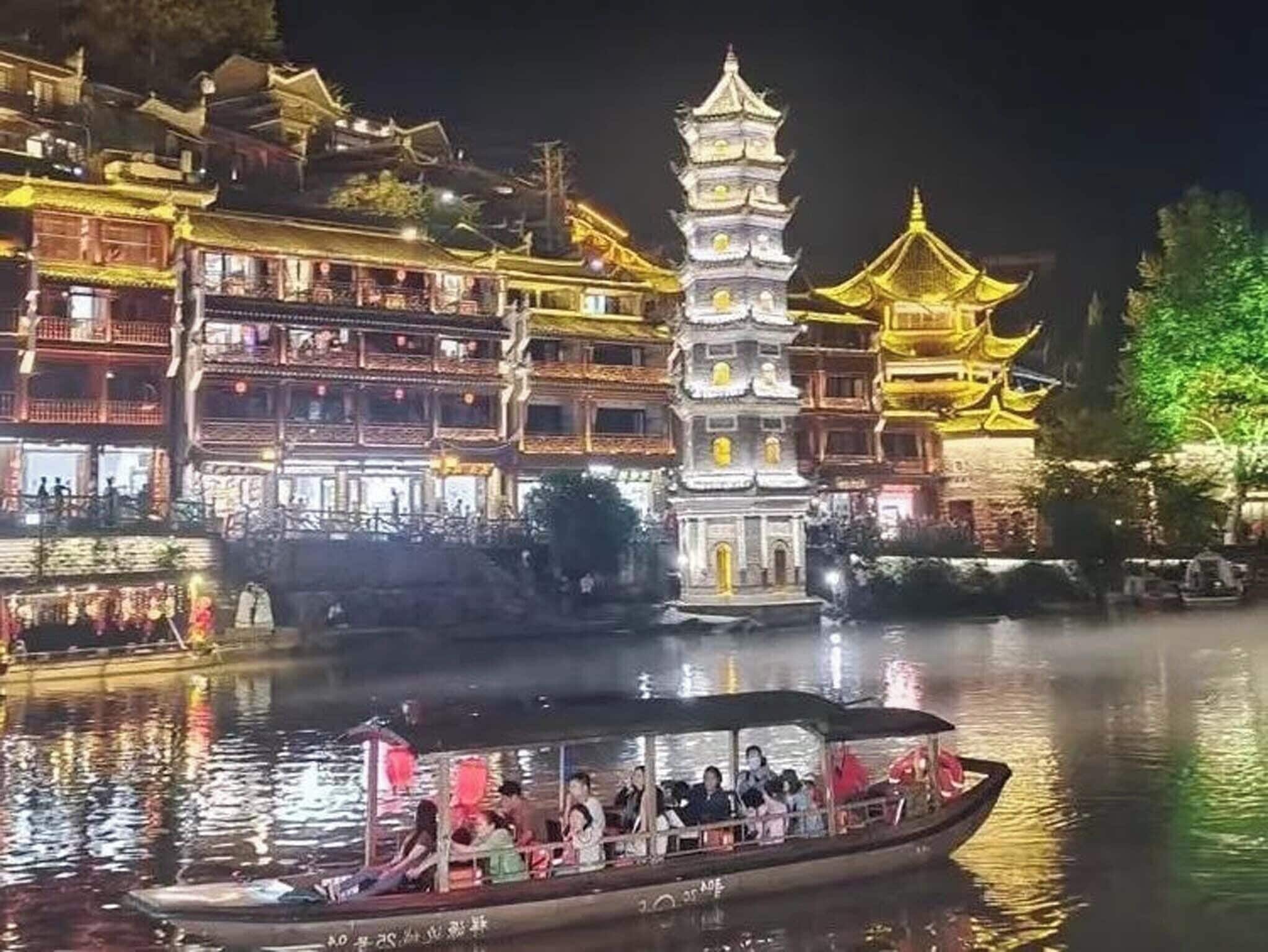 A traditional building with multiple tiers and a pagoda-like structure in the center, surrounded by water.