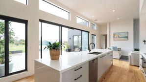 Una cocina moderna con ventanas amplias, una isla central y vistas al exterior.