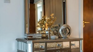 A mirrored vanity with a decorative vase, a metallic object, and a drawer. - Marble Arch Residences (London)
