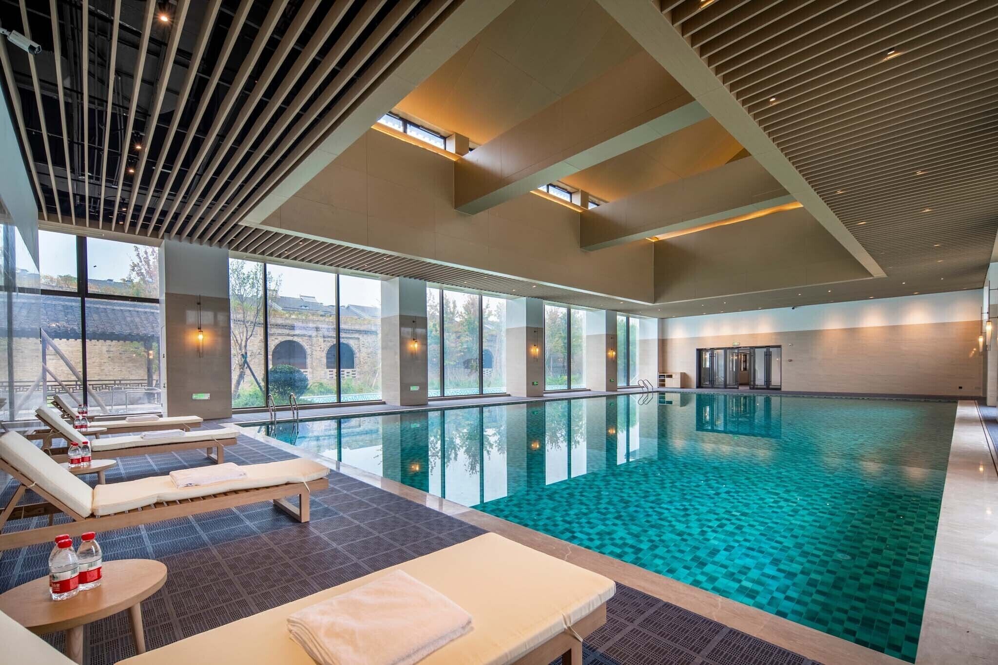 室内游泳池，池畔遮阳伞，日光浴躺椅