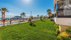 Un hôtel moderne doté d’un balcon donnant sur une plage et une piscine.