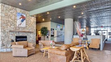 A spacious lobby with a stone fireplace, comfortable seating, and a large pillar.