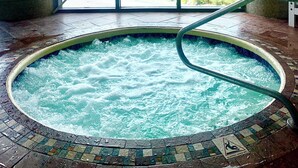 Een hottub met een betegelde vloer en een veiligheidsteken dat aangeeft glad wanneer nat.