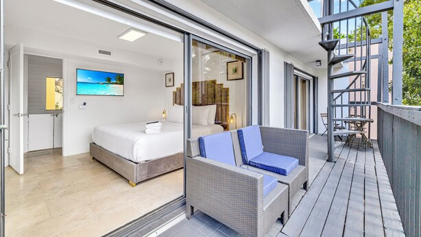 A bedroom with a bed, a sofa, and a TV on the wall. - Rare Brickell Miami House - Walk to Nightlife / Dining / Shopping (Miami)