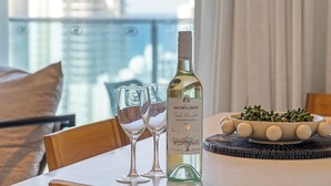 Una ampolla de Jacob's Creek Cool Harvest Sauvignon Blanc 2025 sobre una taula, amb dos vasos i un bol d'olives.