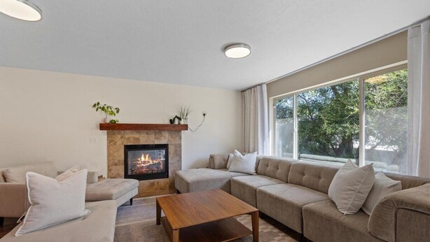 A living room with a fireplace, two sofas, a coffee table, and large windows. - Spacious and comfortable 5-bedroom house near Whitworth University (Spokane)