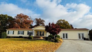 A two-story house with a front porch, a driveway, and a lawn.