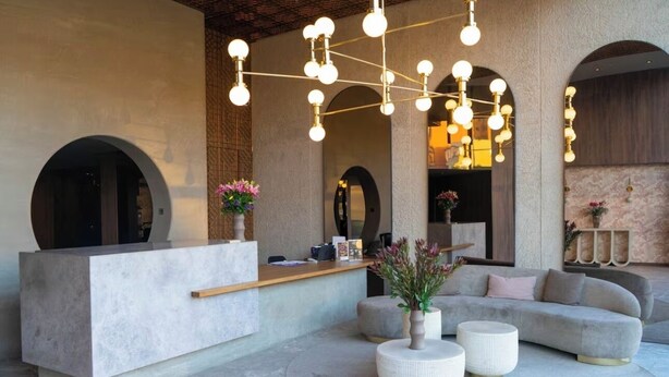 Un espace d’accueil doté d’un comptoir de réception moderne, d’un canapé et d’un luminaire suspendu.
