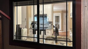 A kitchen with a large window, white cabinets, and a granite countertop. - A&C WATERFORD COTTAGE # 3 (Victoria)