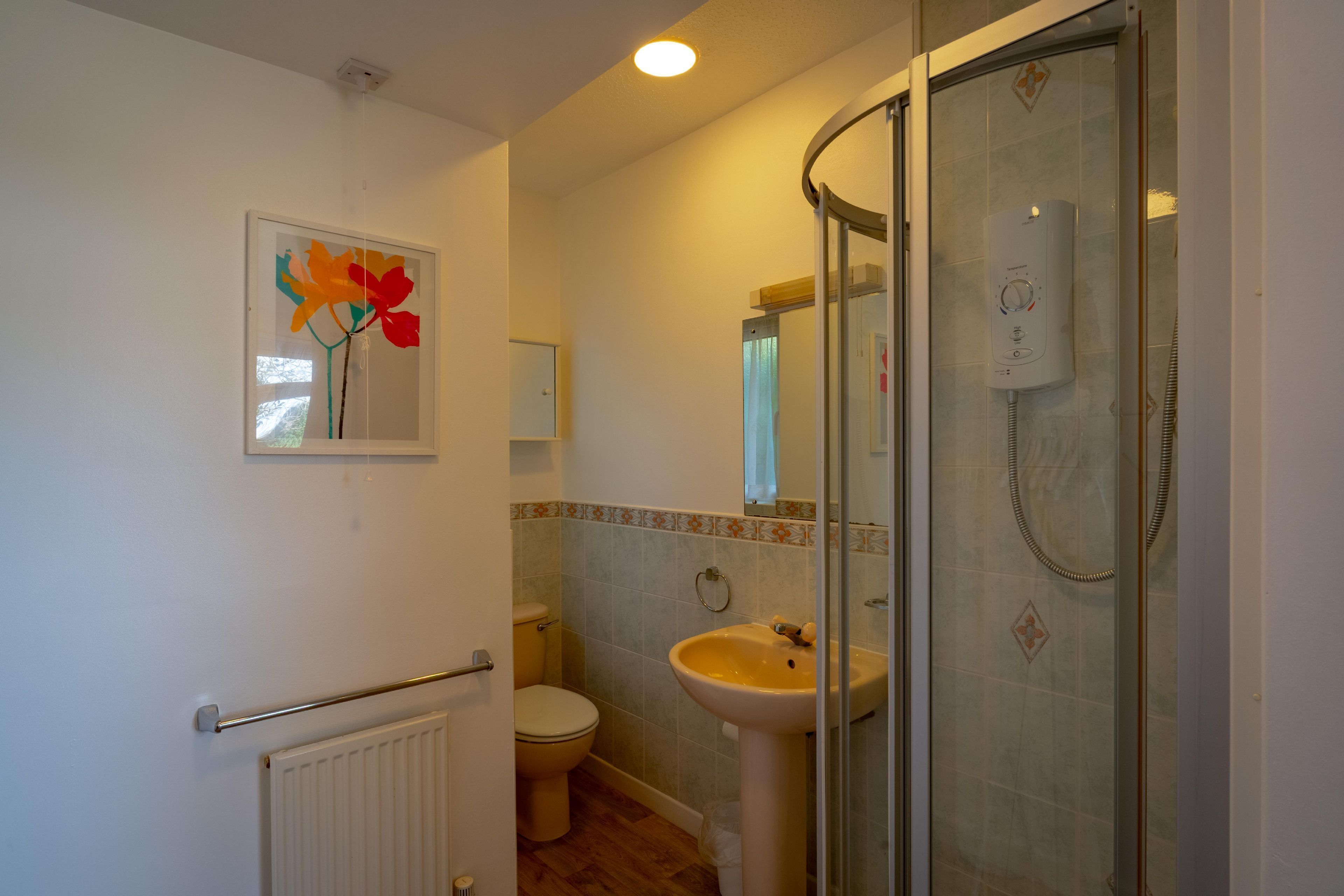 Un baño con inodoro, lavamanos y cabina de ducha de vidrio.