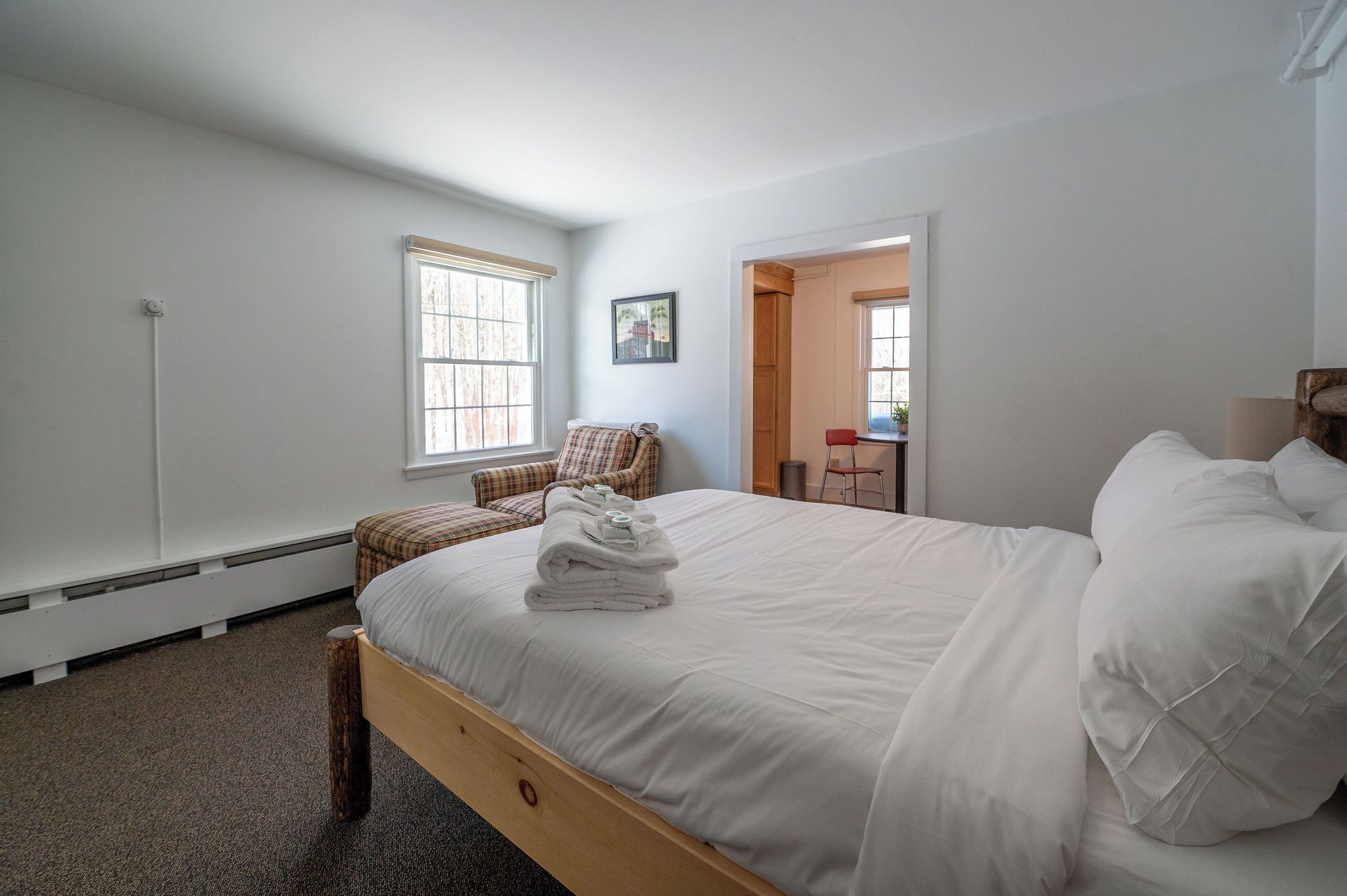 Une chambre avec un grand lit, une chaise et une petite table.