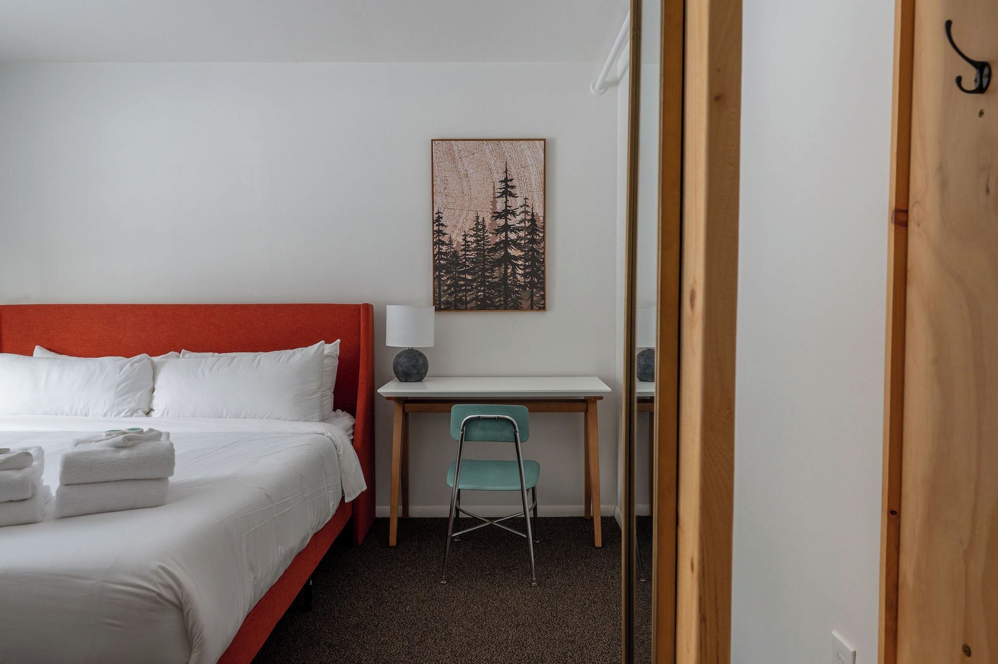 A hotel room with a bed, a desk, and a chair.