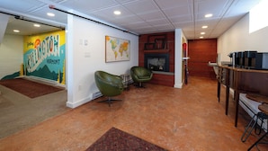 A modern interior with a kitchen area, seating, and a fireplace. - Killington Haus (Killington)