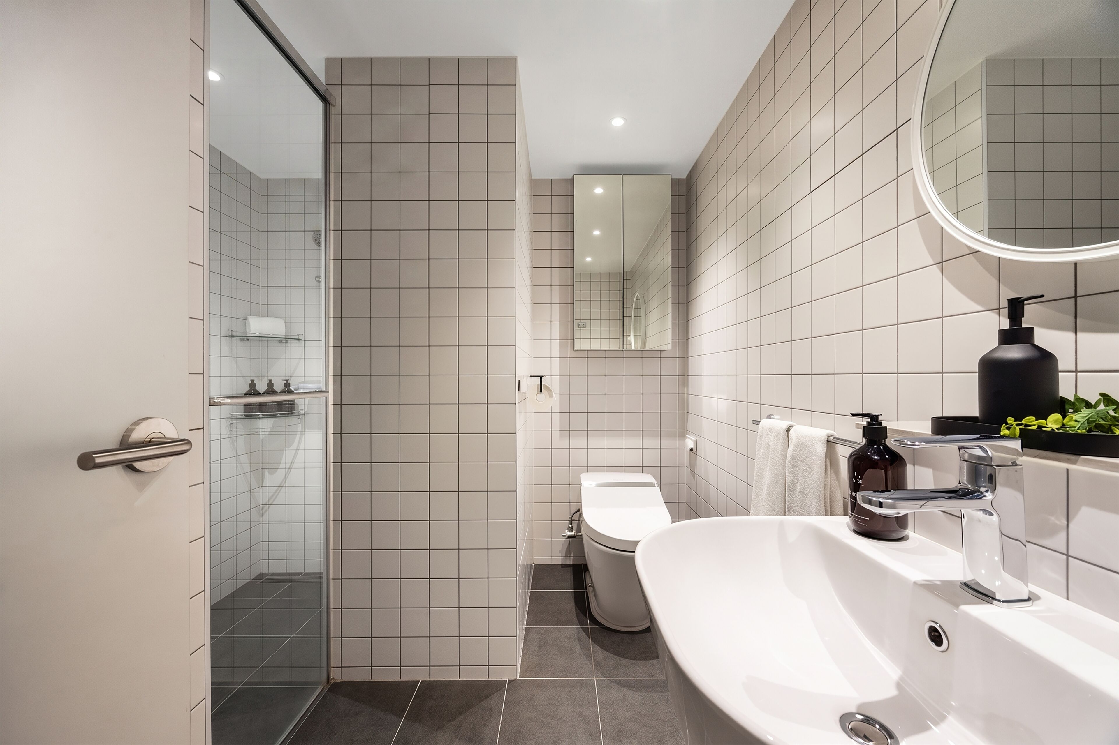Un baño moderno con ducha, inodoro y lavamanos.